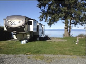 Fifth-wheel trailer parked at an oceanview campsite