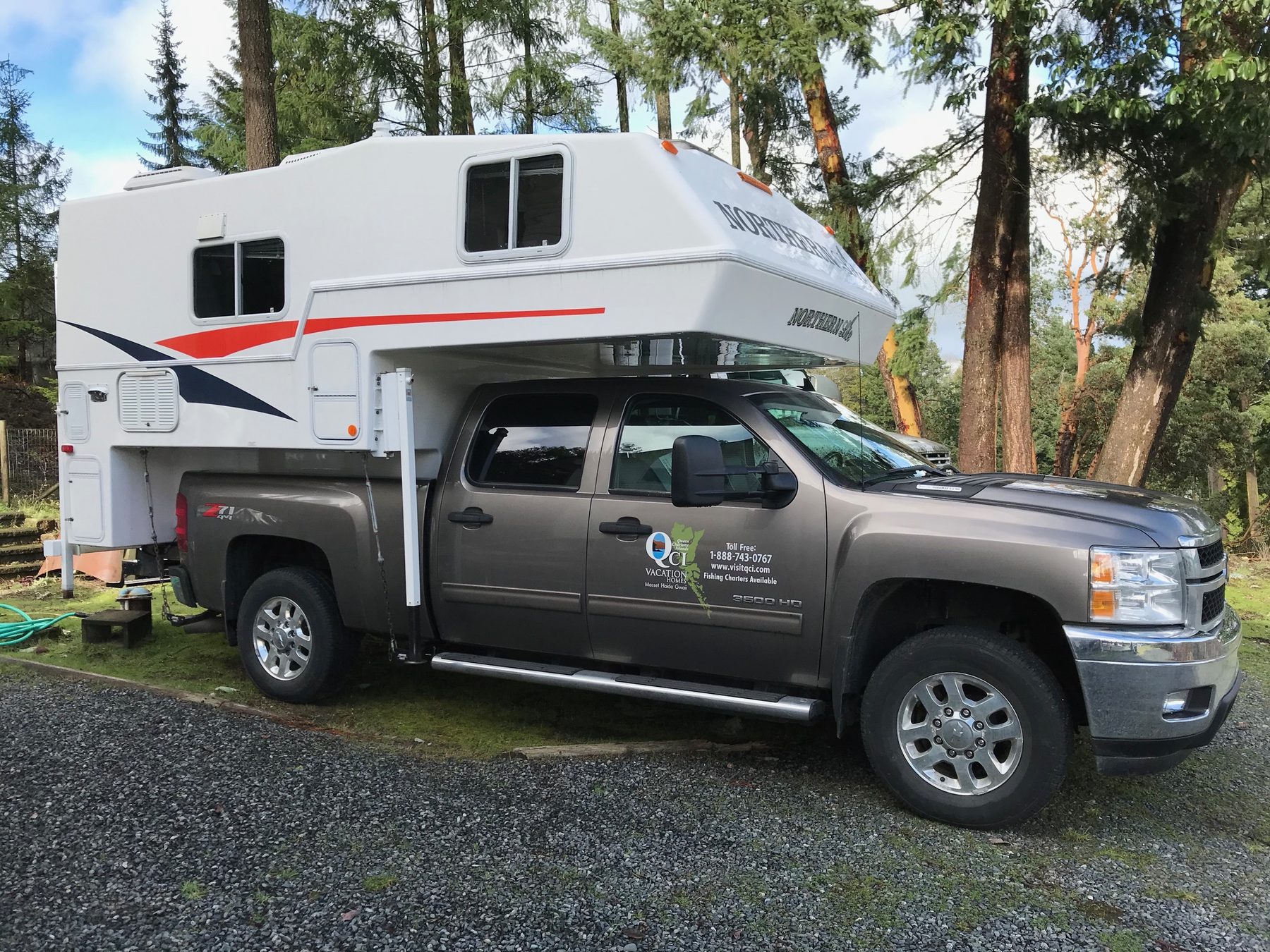 Northernlite camper on a Chevy Silverado truck among tall trees