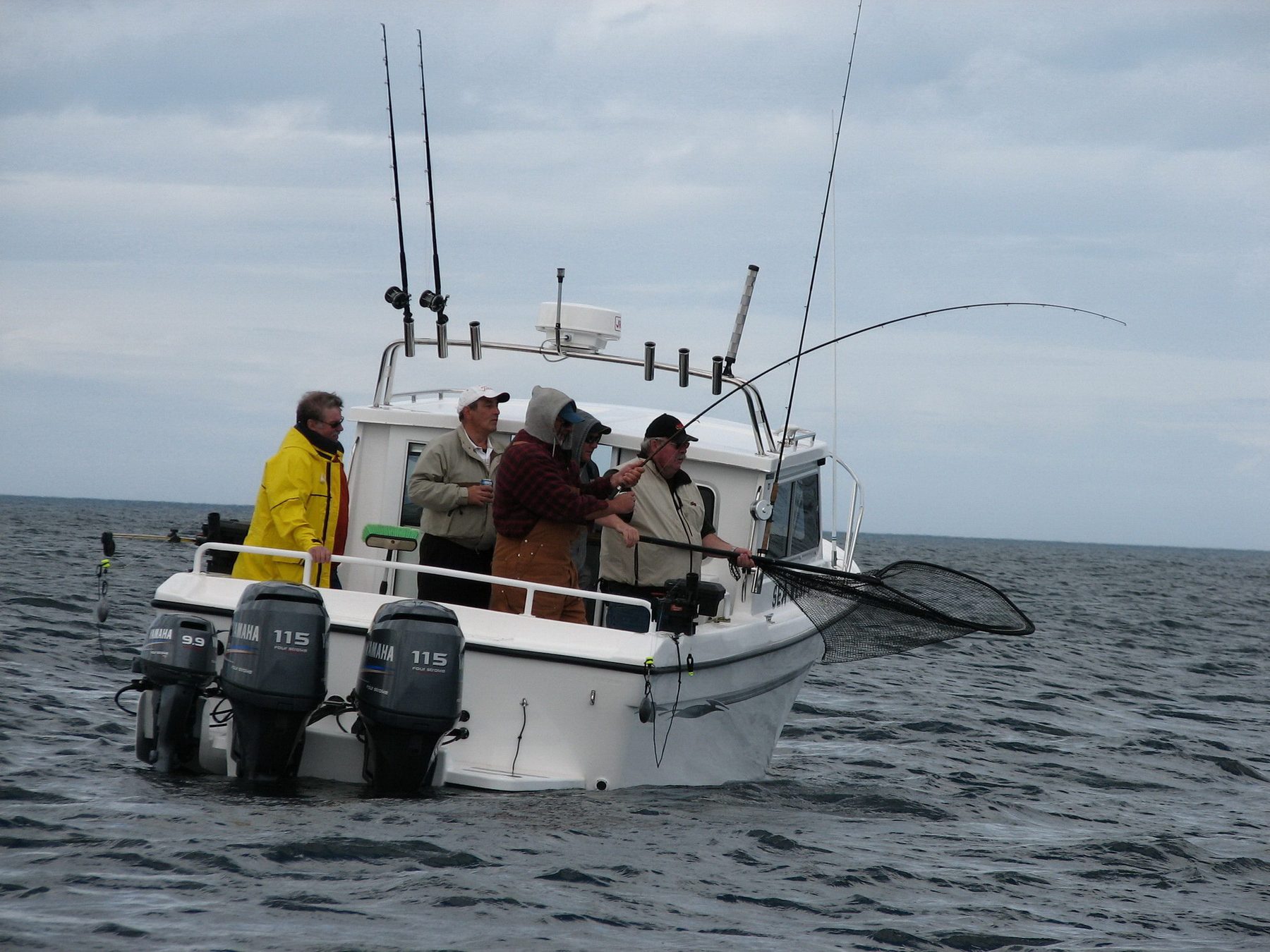 Guide netting a fish beside the Sea West